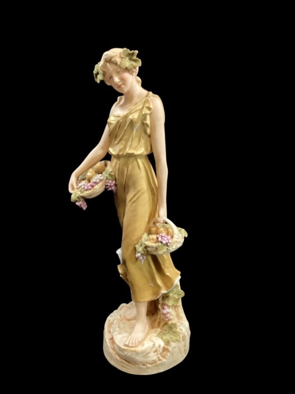 Royal Dux Bohemian Porcelain: Figural sculpture in Art Nouveau style, featuring classic figure of young woman, 20 inches tall, carrying baskets of fruit. Lovely matte, bisque finish, muted colors. Bears the distinctive pink