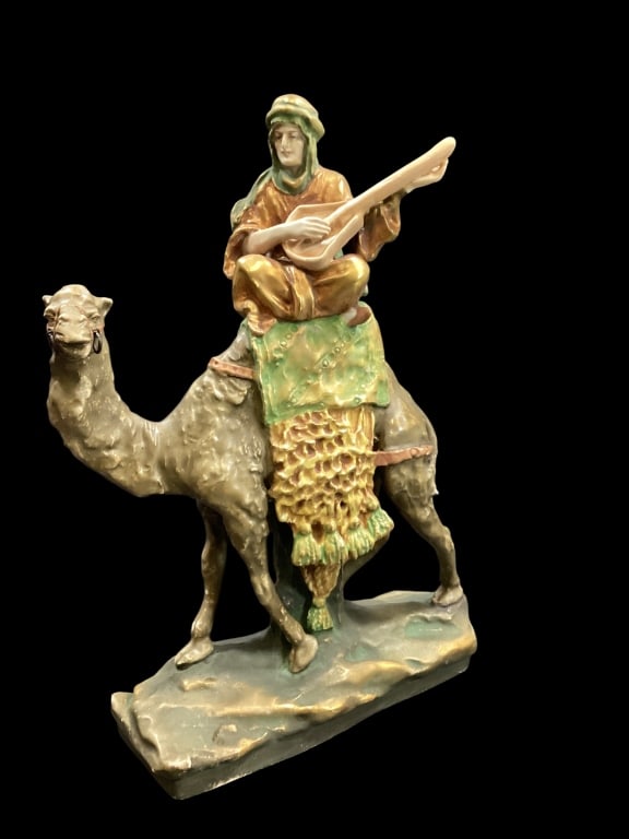 Turn Teplitz Amphora Figural: Porcelain Figure of camel and rider, playing an instrument. Vivid color gold and green attire. 12 inches tall, Amphora stamp * camel missing lead - ()