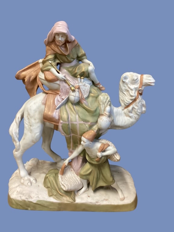 Royal Dux Figural Sculpture: Attribution to Royal Dux, this large scale figure of an Arab Bedouin riding a camel, measures 24 x 18 inches. Soft matte colors to entire piece. * some glitter dust ( not attached), possibly used in a