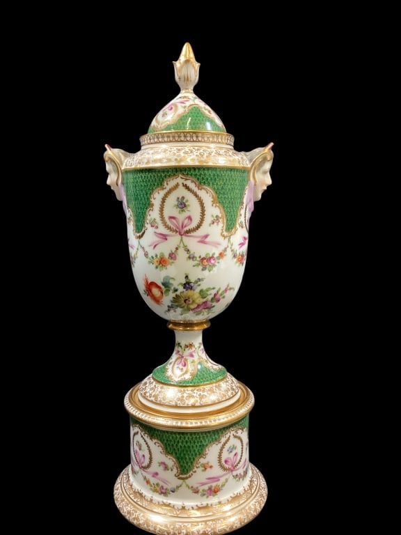 Dresden Porcelain Urn: Exquisite lidded mantle urn, with intricate green and floral decoration, gold gilt adorned elements. Distinctive textured ground with lovely swags, ribbons, double sculpted faces as handles. 14 inches