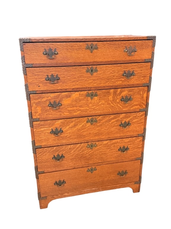 Antique Campaign Style Brass Bound Oak Dresser: Striking antique turn-of-the-century Campaign style tall chest of drawers crafted from beautifully figured quarter-sawn tiger oak. Features a six-drawer vertical stack configuration exhibiting rich,