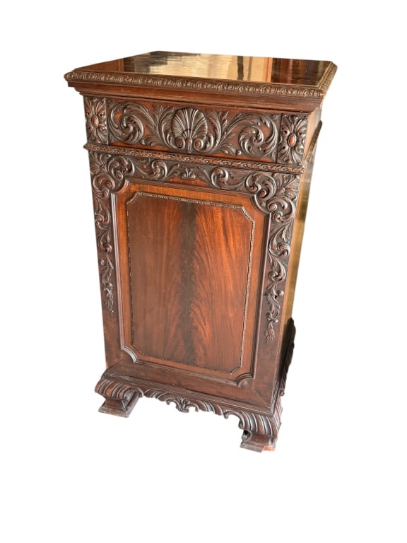 Chippendale Style Carved Pedestal Cupboard: Chippendale style mahogany pedestal cupboard or commode cabinet featuring a highly figured flame mahogany front door panel. The cabinet is ornately embellished with deep acanthus leaf and shell carvin