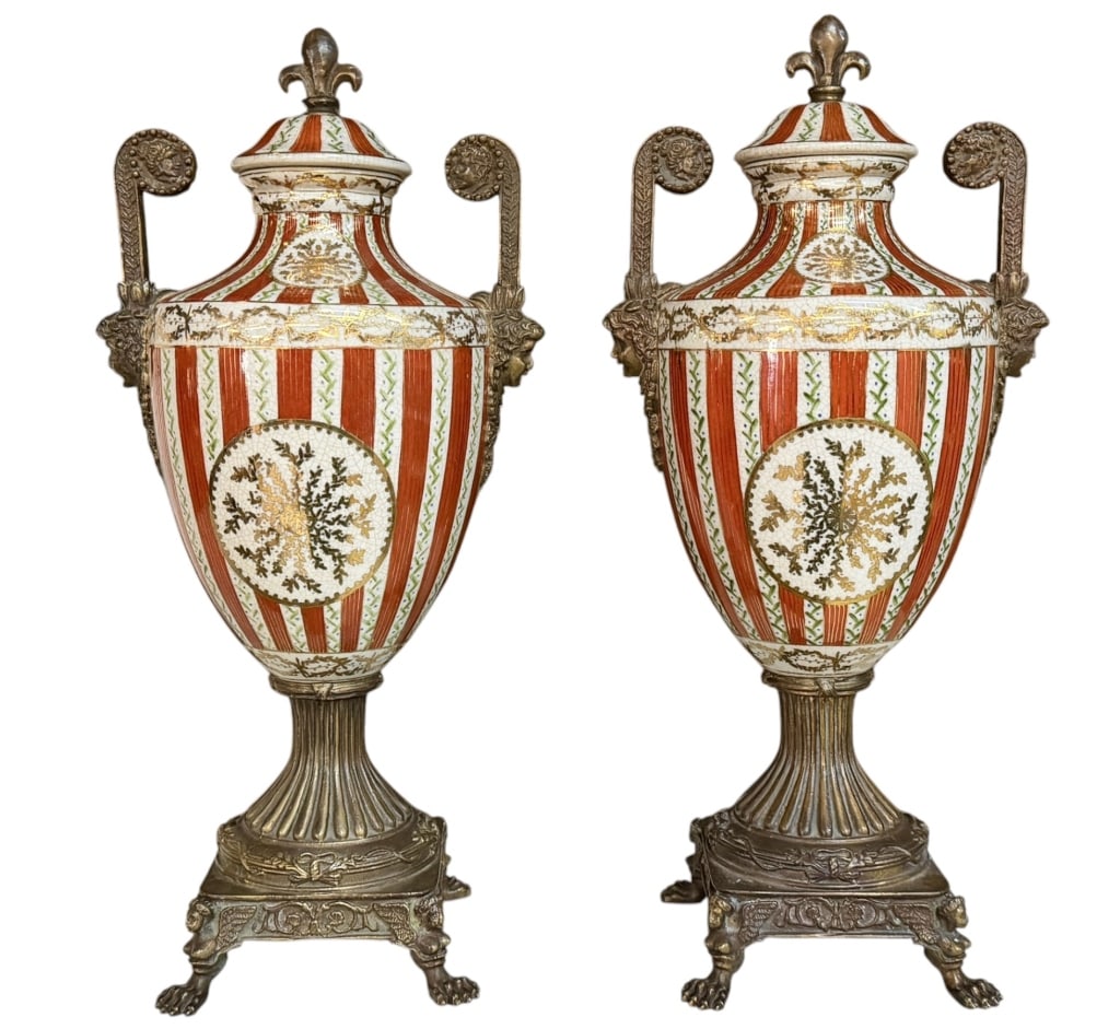 Pair United Wilson Mantle Urns: Pair United Wilson Mantle Urns Late 20th century, orange and white striped lidded urns with gilt accents, crackle glaze, bronze bases and handles, fleur de lis finial..very good estate condition.. eac