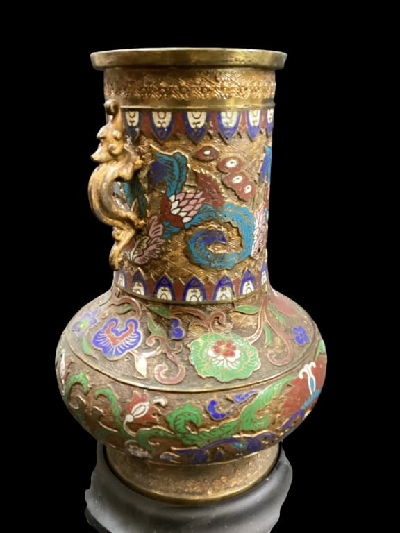 Japanese Champleve Vase: Japanese Champleve Vase Bronze vase with inlaid enamel decoration. 16 inches tall with lotus and chrysanthemum flowers, dragon form handles. Mounted to fitted wooden base.