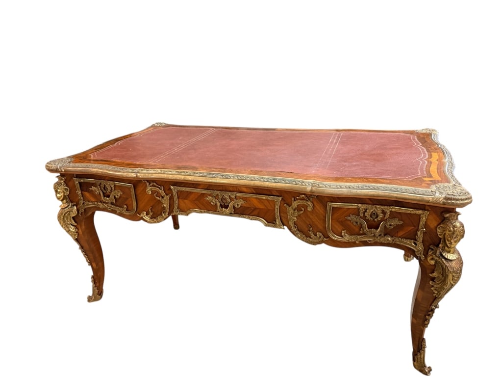 French Style Ormolu Mounted Bureau Plat Desk: French Style Ormolu Mounted Bureau Plat Desk A grand, reproduction or vintage French Louis XV style bureau plat (writing desk). The serpentine-shaped top is inset with a tooled faux-leather writing su