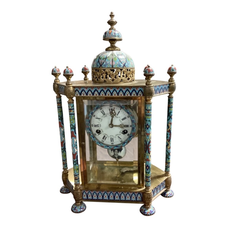 Enameled Brass and Glass Mantle Clock: French A brass mantle clock adorned with vibrant cloisonne enamel designs and glass panels. Features a white enamel dial, Roman numerals, visible pendulum, and intricate finials. Condition is
