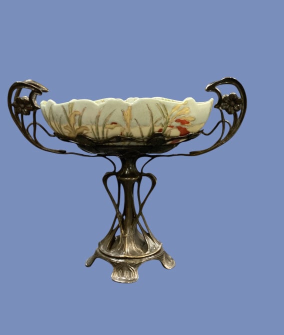 German Art Nouveau Centerpiece: Beautifully crafted silver plate centerpiece bowl with organic flowing floral handles, and graceful center support. The center bowl of pastel porcelain with hand painted florals. 10 x 14 inches