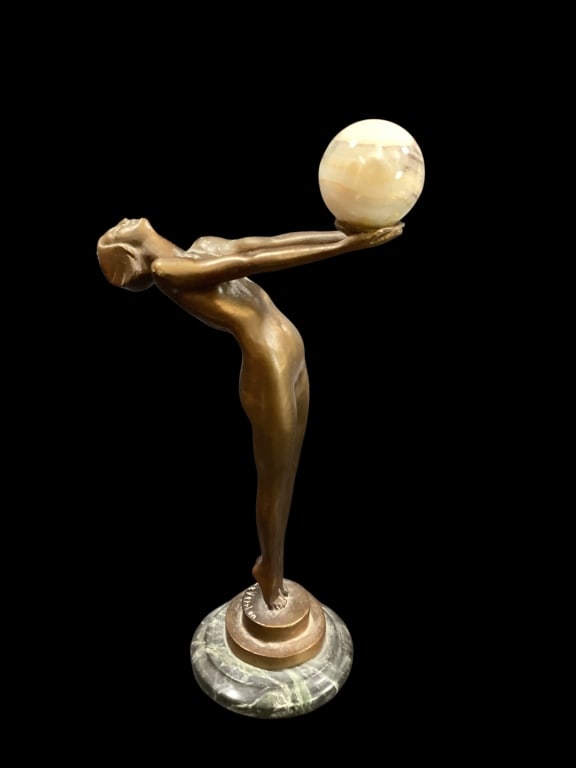 Art Deco Bronze Sculpture: After French Artist Max Le Verrier, featuring a stylized female form nude in a dramatic pose balancing a sphere on outstretched arms. Patinated finish she stands on a multi tier circular base. Holding