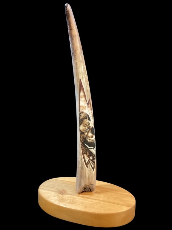 Fine Scrimshaw Engraving: Walrus tooth featuring an Intricate engraving of Inuit Mother holding an infant in a Amauti parka. Beautiful done in traditional style by Artist H. Robichaud, Signed and dated 2004, Glacier Bay
