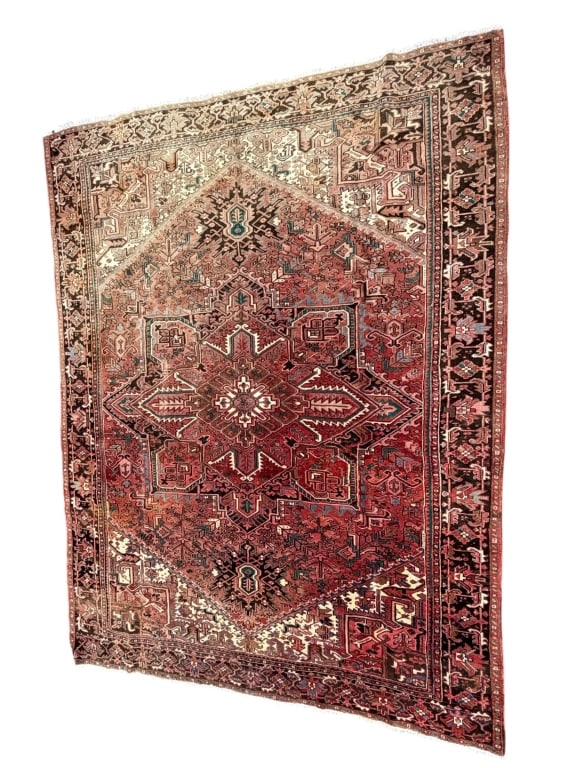 Heriz Wool Area Rug: Traditional Persian Heriz hand-knotted wool area rug featuring a prominent geometric starburst medallion in red, black, and cream. Bold angular motifs and a detailed border create a strong, structured