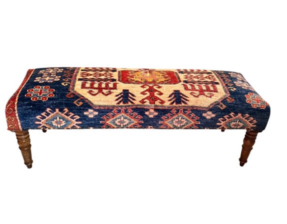 Kilim/Kazak-Upholstered Turned-Leg Bench: Charming accent bench upholstered in a vintage hand-knotted Caucasian Kazak-style rug fragment, showcasing bold tribal medallions, rosettes, and tree-of-life motifs in rich indigo, cream, and red