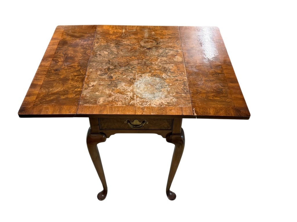 Walnut Drop Leaf Table: Antique walnut drop-leaf side table in the Queen Anne or George I revival style. The table features a rectangular, banded top with hinged drop leaves, a single frieze drawer, and graceful cabriole