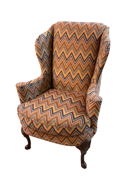 Zigzag Wingback Chair: Classic wingback armchair upholstered in a vibrant, multicolored zigzag flame-stitch fabric. The high winged back, rolled arms, and traditional silhouette give the chair a timeless character, while th