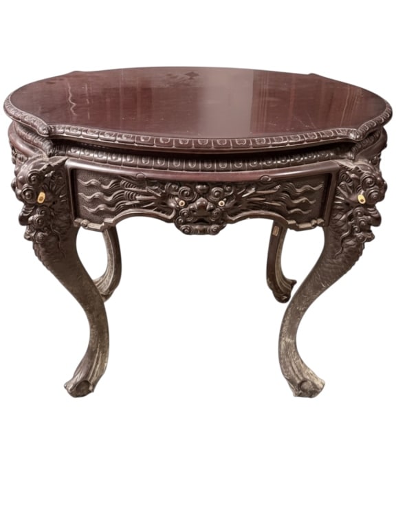 Chinese Carved Hardwood Center Table: Superb Chinese carved hardwood center table, oval top with egg-and-dart carved edge over a boldly sculpted apron. Each cabriole leg terminates in a ferocious dragon-mask carving with inset glass