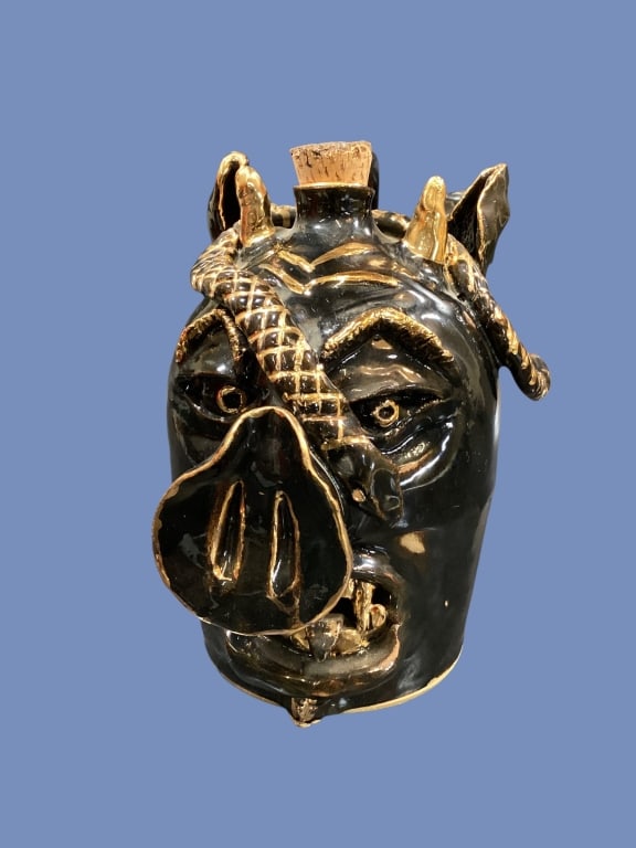 Southern Folk Art Face Jug: Hand Crafted stoneware Ugly pig face with devil horns and coiling snake, all the elements of a grotesque face jug brought together. Dark glossy glaze with applied gold trim. Signed F. Ray, Full Moon P