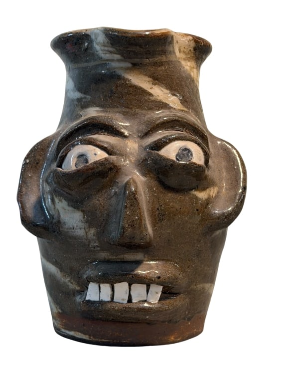Burlon Craig Face Jug: Southern folk art face pitcher by North Carolina potter Burlon Craig. The pitcher features a distinctive swirled clay body made from contrasting light and dark clays, along with bulging eyes, and a
