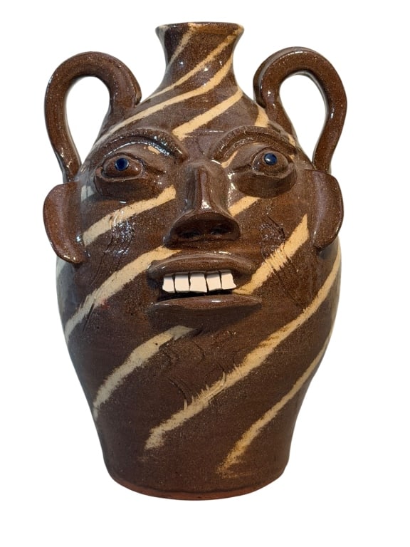 Walter Fleming Face Jug: Southern folk art face jug by North Carolina potter Walter Fleming. The jug features a distinctive swirlware body made from contrasting light and dark clays, creating a striped pattern across the surf