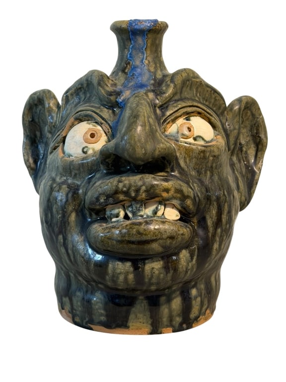 William Flowers Face Jug: Southern folk art face jug by North Carolina potter William "Bill" Allen Flowers. The jug features a deep green and brown streaked alkaline glaze with cobalt blue highlights around the spout and