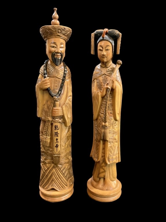 Pair Hand Carved Chinese Figures: Representing Emperor Qianlong and his Empress. He wears traditional court beads and headgear, she holds ceremonial Ruyi with imperial hairstyle. Crafted in boxwood, they stand 14 and 13 inches tall.