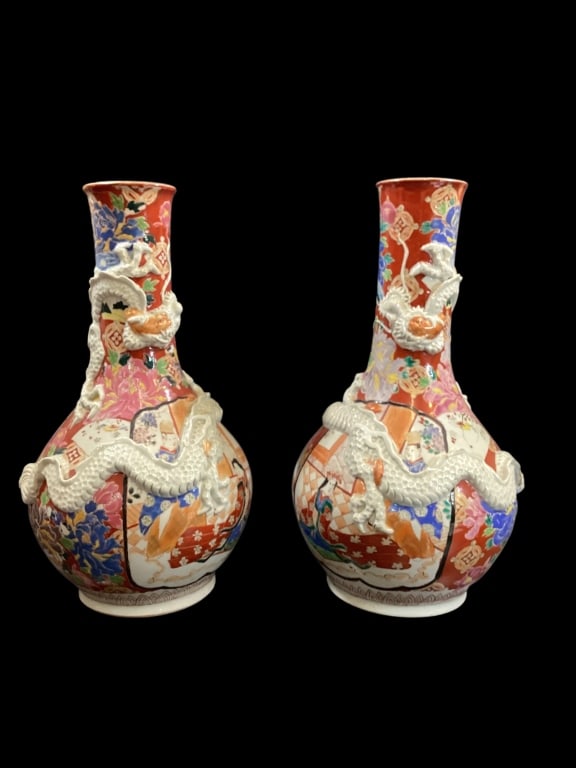 Pair Japanese Porcelain Vases: Meiji Period Arita Polychrome porcelain vases with applied Moriage undulating dragon. Beautifully decorated with circular reserves, naturalist elements, on iron red ground. 16 inches tall,