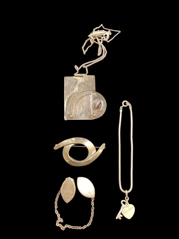 Collection of Mostly Sterling Jewelry: Circle brooch stamped Mexico, retro Sterling sweater gourd clips, 2 Sterling small charms on rope bracelet, Plotner Modernist Sterling pendant, set with small gemstone ( chain not marked).