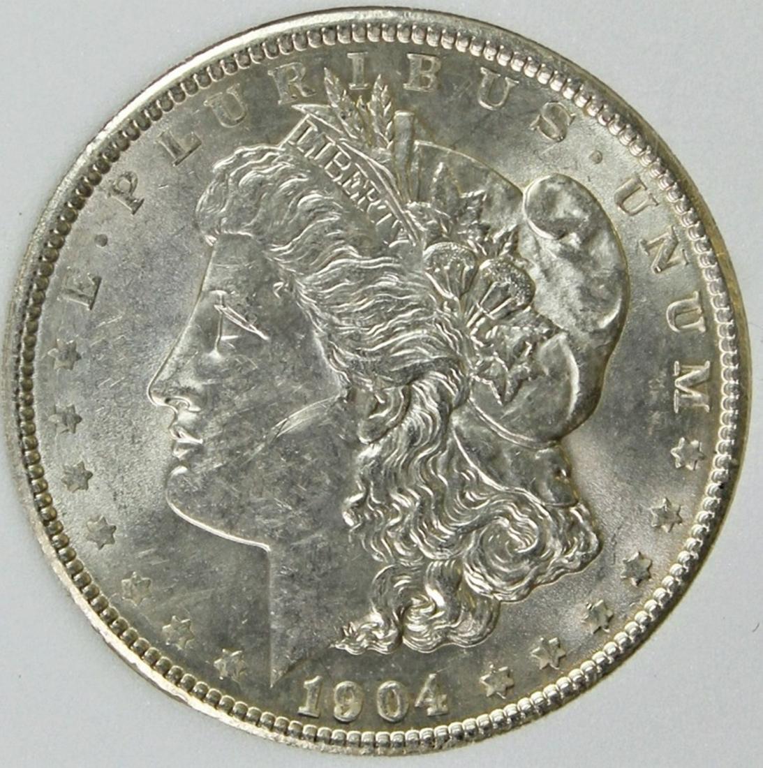 1904 MORGAN SILVER DOLLAR: NGP GRADED. GEM BU. WHITE AND NICE! ESTIMATE: $975-$1100
