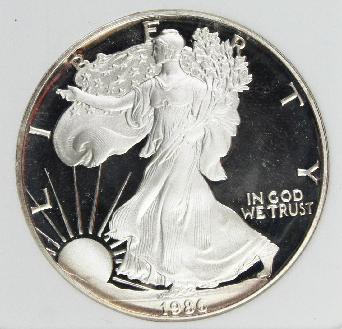 1986 AMERICAN SILVER EAGLE: PERFECT PROOF DEEP CAMEO. AGP GRADED. COMES WITH BOX AND CERT. ESTIMATE: $330-$400