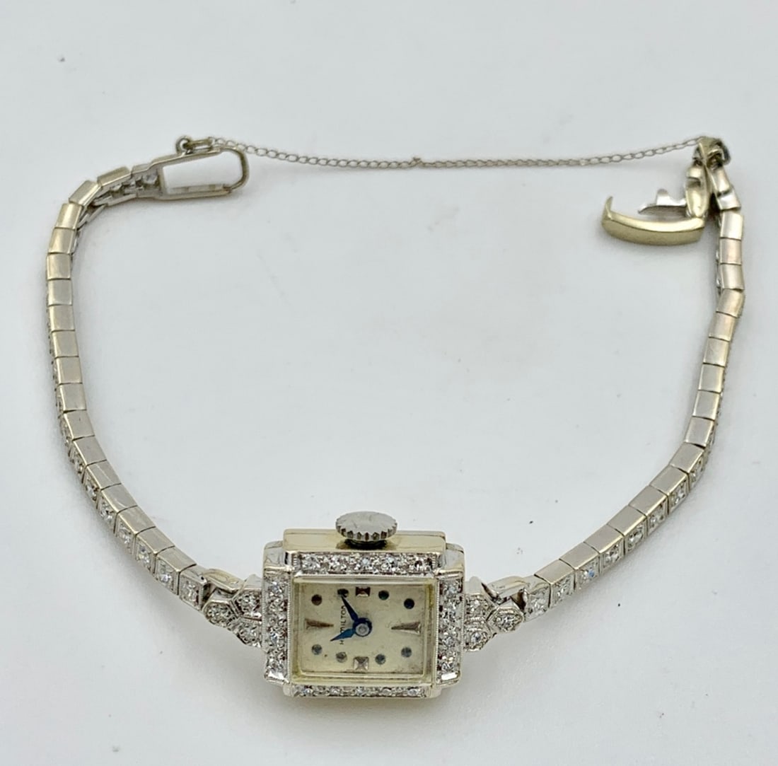LADIES 14K WHITE GOLD ART DECO DIAMOND HAMILTON: WATCH, FACE IS SURROUNDED BY 24 DIAMONDS AND THE WATCH BAND CONTAINS 36 DIAMONDS FOR A TOTAL OF 60 DIAMONDS FOR AN ESTIMATED 1.85 TDW. MOVEMENT SERIAL # 773122A WHICH DATES THIS WATCH 1907-1910. 17 JE