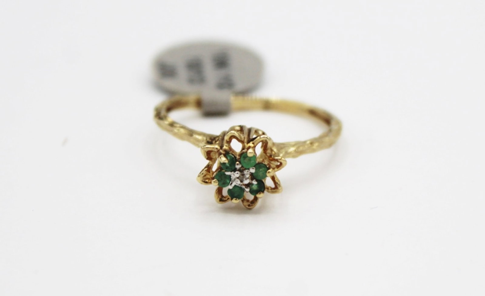 10 KT GOLD RING: SIZE 7. WITH GREEN RHINESTONES. .8 DWT. ESTIMATE: $100-$150