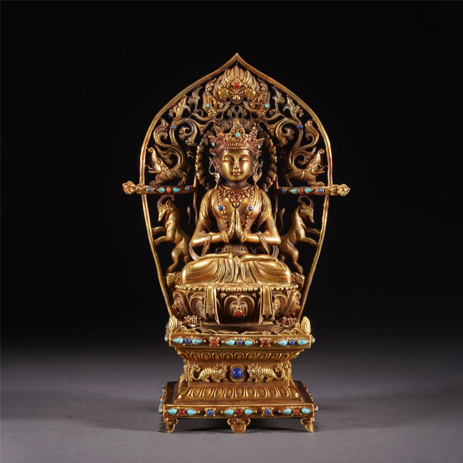 A HARD STONES INLAID GOLD SEATED CROWNED BUDDHA: A HARD STONES INLAID GOLD SEATED CROWNED BUDDHA The deity is depicted seated in dhyanasana on a lotus base with beaded rim, with the hands in Namaskara Mudra, the figure is dressed in robes, with a se