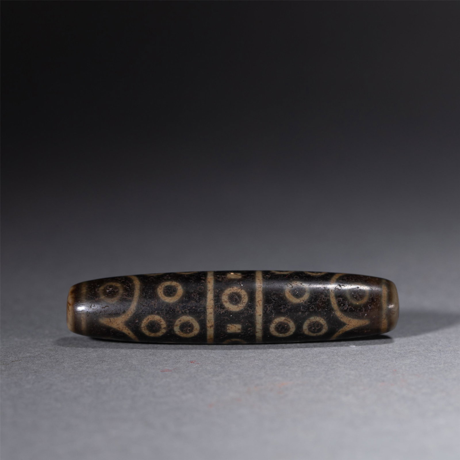 A FINE AND RARE TIBETAN DZI BEAD (1 of 9)