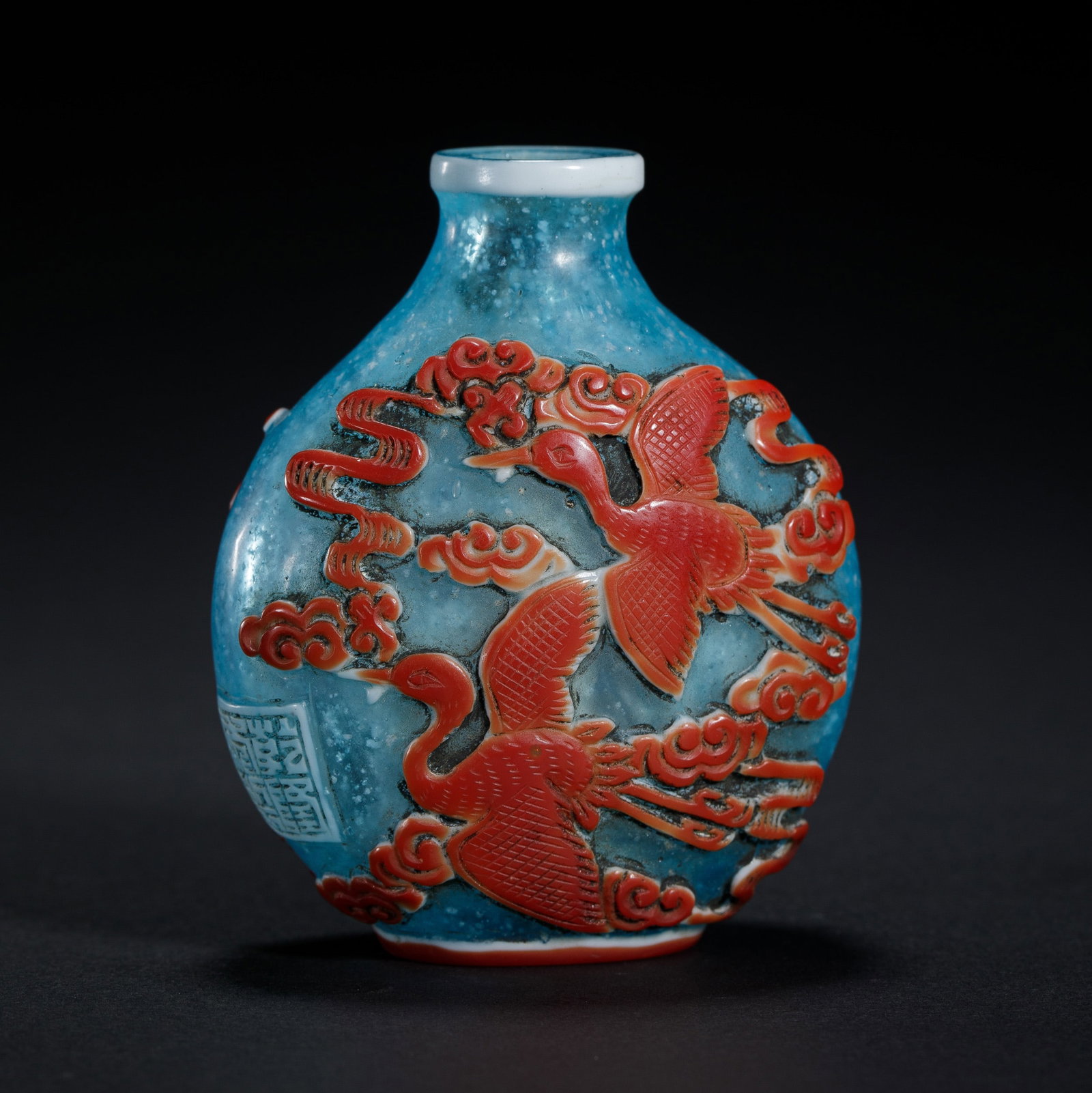 A PEKING GLASS OVERLAY SNUFF BOTTLE: A PEKING GLASS OVERLAY SNUFF BOTTLE Of compressed ovoid shape, carved flying cranes among clouds. Dimension: L. 5 cm. W. 2.7 cm. H. 6.2 cm. Weight 52 grams.