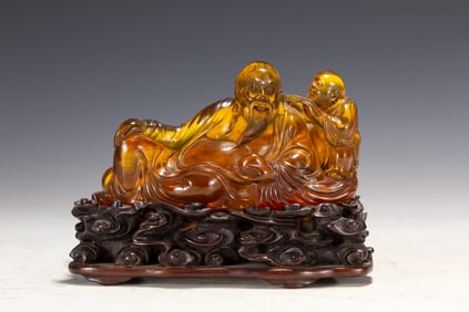 A CARVED AMBER LUOHAN