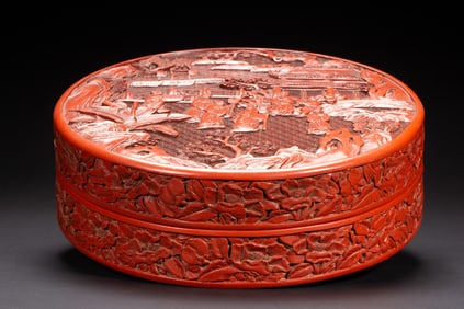 A FINE CARVED CINNBAR LACQUER FIGURAL STORY BOX WITH COVER