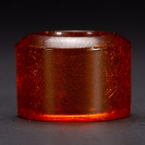 A CARVED AMBER ARCHER RING