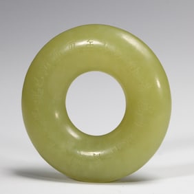 A CHINESE INSCRIBED YELLOW JADE DISC HUAN