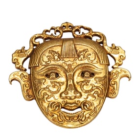 A BRONZE-GILT HUMAN MASK