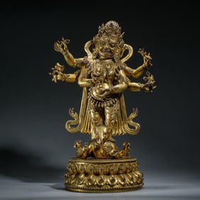 A BRONZE-GILT STANDING MAHAKALA