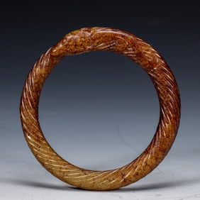 A CARVED JADE BANGLE
