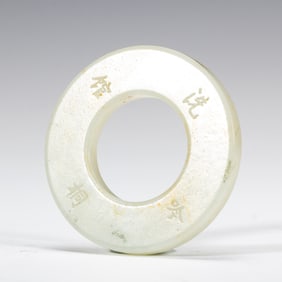 AN INSCRIBED WHITE JADE DISC HUAN