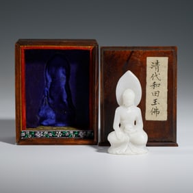 A CARVED WHITE JADE SEATED BUDDHA