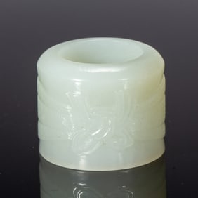 A CARVED WHITE JADE ARCHER RING