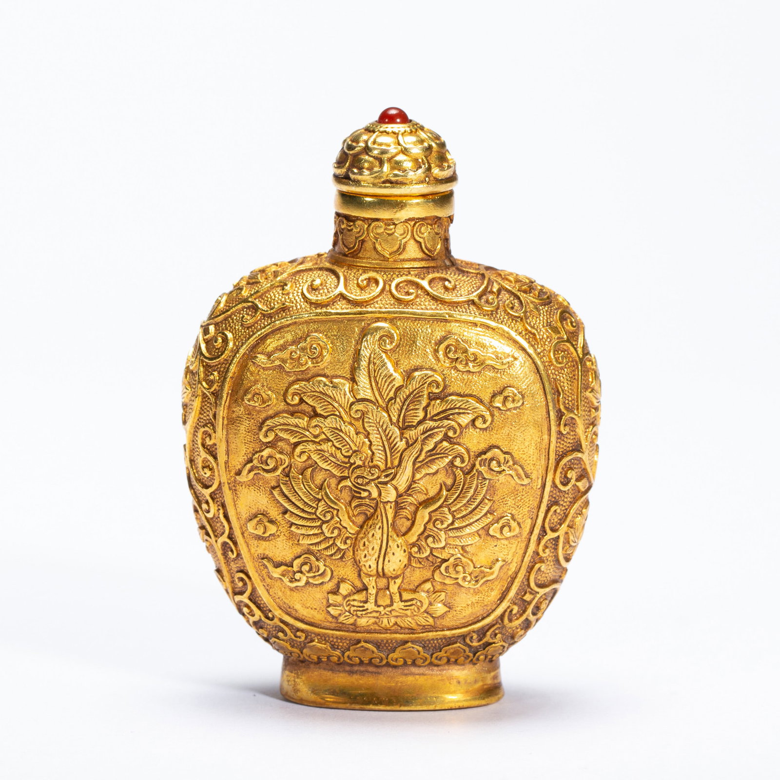A BRONZE-GILT PHOENIX SNUFF BOTTLE: A BRONZE-GILT PHOENIX SNUFF BOTTLE Of baluster shape, casted with phoenix at the reserved cartouche, richly gilt, with matched stopper. Dimension: L. 5.5 cm. W. 3.2 cm. H. 7.7 cm. Weight 120 grams.