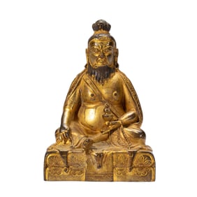 A BRONZE-GILT SEATED SIDDHA