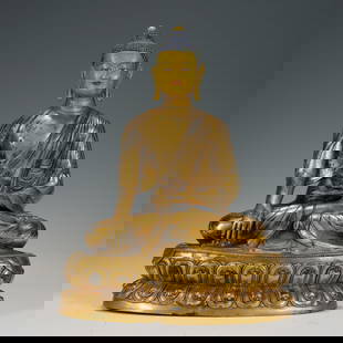 A BRONZE-GILT SEATED SHAKYAMUNI: A BRONZE-GILT SEATED SHAKYAMUNI This magnificent sculpture elegantly depicts the moment at which Buddha Shakyamuni achieves enlightenment. Faced with the threats and temptations of Mara, Buddha overco