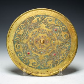 A BRONZE PARTLY GILT MIRROR