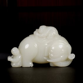 A CARVED WHITE JADE BOYS ON ELEPHANT