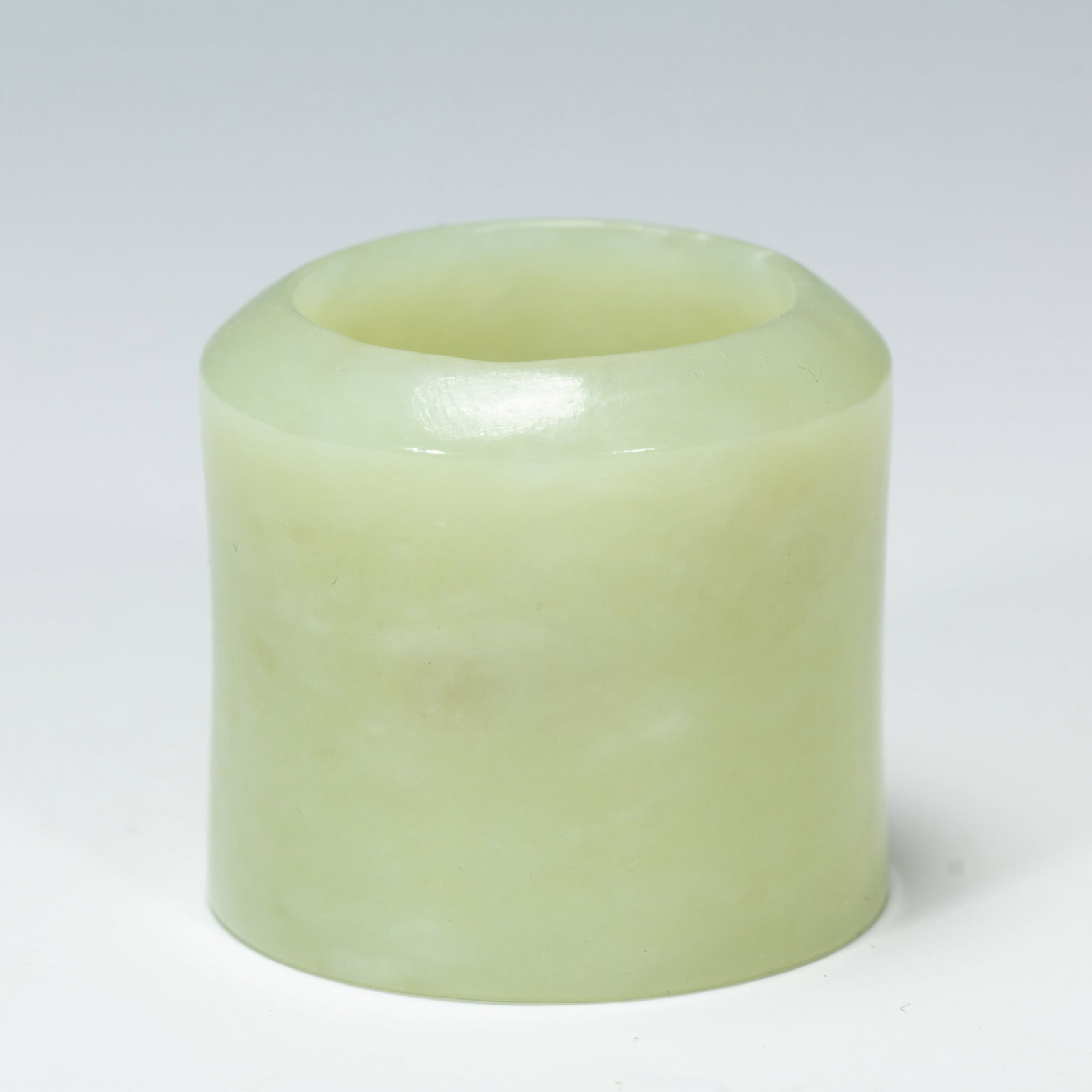A WHITE JADE ARCHER RING: A WHITE JADE ARCHER RING An archer’s ring, cylindrical in form with a flat base and a diagonally-cut top. It is wearable on either the right or left thumb. To use the ring, first wear it on the thum