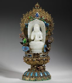 A CARVED WHITE JADE SEATED BUDDHA