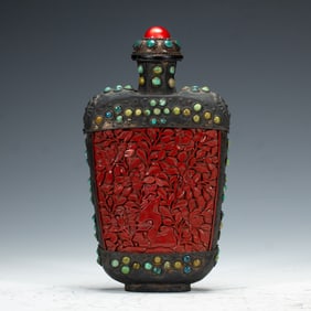 A CARVED CINNABAR LACQUER SNUFF BOTTLE